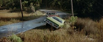 Movie still from “Hopscotch” (1980), directed by Ronald Neame – Two cars that are in the grass near a road; Extreme Wide shot, High angle