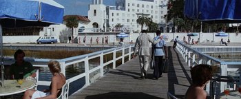 Movie still from “Hopscotch” (1980), directed by Ronald Neame – Two people walking on a boardwalk near the water; Wide shot, Low angle