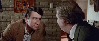 Movie still from “Hopscotch” (1980), directed by Ronald Neame – A man in a brown jacket is talking to another man in a brown suit; Close Up shot, Over the shoulder angle