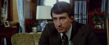 Movie still from “Hopscotch” (1980), directed by Ronald Neame – A person wearing a suit and tie; Close Up shot, Over the shoulder angle