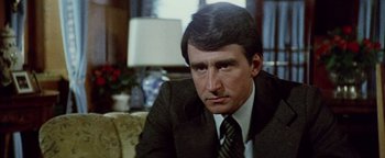 Movie still from “Hopscotch” (1980), directed by Ronald Neame – A person wearing a suit and tie; Close Up shot, Over the shoulder angle