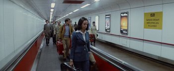 Movie still from “Hopscotch” (1980), directed by Ronald Neame – A group of people walking down a train platform with suitcases; Wide shot, High angle