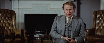 Movie still from “Hopscotch” (1980), directed by Ronald Neame – An older man sitting in front of a fire place; Medium shot, Over the shoulder angle