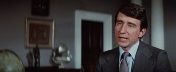 Movie still from “Hopscotch” (1980), directed by Ronald Neame – A person wearing a suit and tie; Close Up shot, Over the shoulder angle