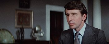 Movie still from “Hopscotch” (1980), directed by Ronald Neame – A person wearing a suit and tie; Close Up shot, Low angle