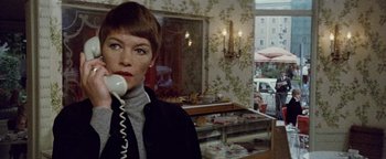 Movie still from “Hopscotch” (1980), directed by Ronald Neame – A woman holding a phone to her ear while standing in a room; Close Up shot, Low angle