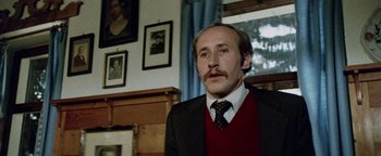 Movie still from “Hopscotch” (1980), directed by Ronald Neame – A man in a suit and tie in front of a window; Close Up shot, Low angle