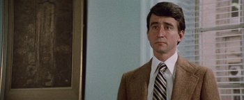 Movie still from “Hopscotch” (1980), directed by Ronald Neame – A person wearing a suit and tie; Close Up shot, Over the shoulder angle