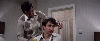 Movie still from “Hopscotch” (1980), directed by Ronald Neame – A man getting his hair combed by another man; Close Up shot, Over the shoulder angle