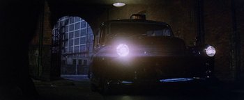 Movie still from “Hopscotch” (1980), directed by Ronald Neame – A taxi cab is lit up by a street light; Wide shot, Low angle