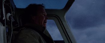 Movie still from “Hopscotch” (1980), directed by Ronald Neame – A man in a helicopter at night with the sky in the background; Medium shot, Low angle