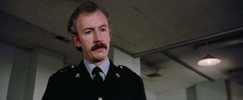 Movie still from “Hopscotch” (1980), directed by Ronald Neame – A person wearing a uniform; Close Up shot, Low angle