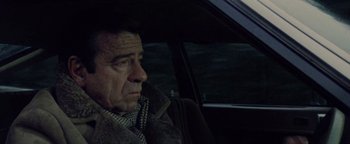 Movie still from “Hopscotch” (1980), directed by Ronald Neame – A man sitting in the driver's seat of a car; Close Up shot, High angle