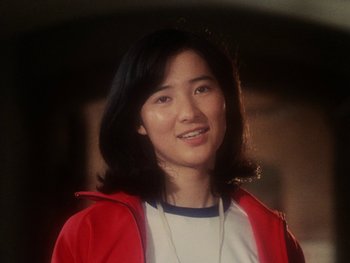 Movie still from “House” (1977), directed by Nobuhiko Ôbayashi – A woman in a red jacket smiling for the camera; Close Up shot, High angle