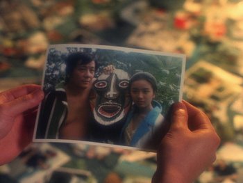 Movie still from “House” (1977), directed by Nobuhiko Ôbayashi – A person holding a picture of a man and woman; Close Up shot, High angle
