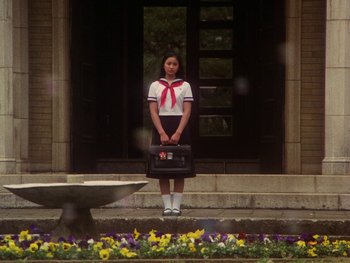 Movie still from “House” (1977), directed by Nobuhiko Ôbayashi – A woman in a school uniform holding a bag; Wide shot, Low angle