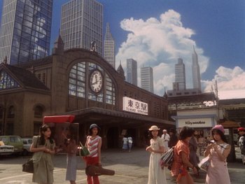 Movie still from “House” (1977), directed by Nobuhiko Ôbayashi – A group of people standing in front of a train station; Extreme Wide shot, High angle