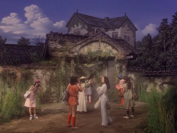 Movie still from “House” (1977), directed by Nobuhiko Ôbayashi – A group of people standing in front of a building; Wide shot, High angle