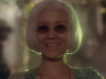 Movie still from “House” (1977), directed by Nobuhiko Ôbayashi – A person wearing glasses and smiling; Close Up shot, Low angle