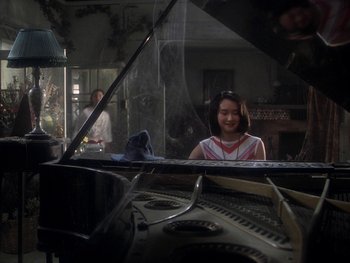 Movie still from “House” (1977), directed by Nobuhiko Ôbayashi – A young girl sitting at a piano in front of a mirror; Medium shot, High angle