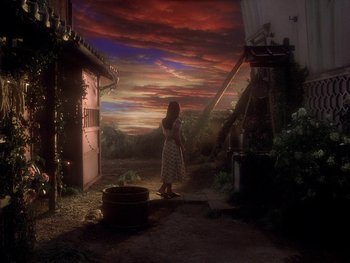 Movie still from “House” (1977), directed by Nobuhiko Ôbayashi – A woman standing in front of an open door in a house; Extreme Wide shot, High angle