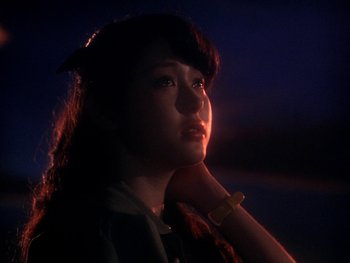 Movie still from “House” (1977), directed by Nobuhiko Ôbayashi – A woman with long dark hair is looking at the camera; Close Up shot, Low angle