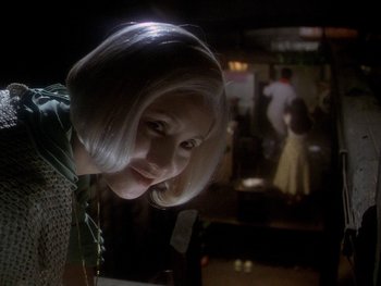 Movie still from “House” (1977), directed by Nobuhiko Ôbayashi – A woman with white blonde hair is smiling; Close Up shot, Over the shoulder angle