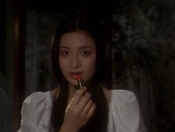 Movie still from “House” (1977), directed by Nobuhiko Ôbayashi – A young woman is holding a lipstick in her mouth; Close Up shot, Over the shoulder angle
