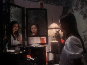 Movie still from “House” (1977), directed by Nobuhiko Ôbayashi – A woman looking in the mirror in front of a mirror; Medium shot, High angle