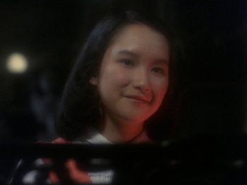 Movie still from “House” (1977), directed by Nobuhiko Ôbayashi – A young woman is looking at the camera through a window; Close Up shot, High angle