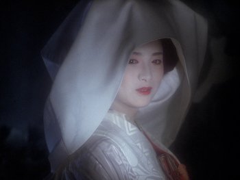 A woman in a white dress with a veil on her head