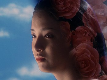 Movie still from “House” (1977), directed by Nobuhiko Ôbayashi – A woman with flowers in her hair is looking into the distance; Close Up shot, Low angle