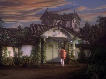 Movie still from “House” (1977), directed by Nobuhiko Ôbayashi – A woman standing in front of an old house; Extreme Wide shot, Low angle
