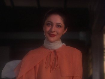 Movie still from “House” (1977), directed by Nobuhiko Ôbayashi – A woman in a pink top is posing for a picture; Close Up shot, Low angle