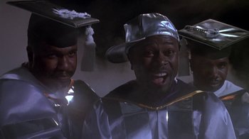 Movie still from “House Party 2” (1991), directed by Doug McHenry – A group of men in graduation caps and gowns; Medium shot, Low angle
