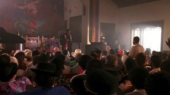 Movie still from “House Party 2” (1991), directed by Doug McHenry – A large group of people sitting in a room; Extreme Wide shot, High angle