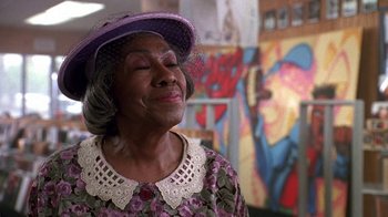 Movie still from “House Party 2” (1991), directed by Doug McHenry – An older woman wearing a purple hat and a purple dress; Close Up shot, Low angle