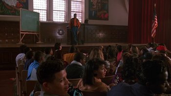 Movie still from “House Party 2” (1991), directed by Doug McHenry – A crowd of people sitting in front of a man on a stage; Wide shot, Low angle