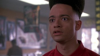 Movie still from “House Party 2” (1991), directed by Doug McHenry – A young man with a mohawk haircut stares into the camera; Close Up shot, Low angle
