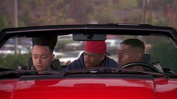 Movie still from “House Party 2” (1991), directed by Doug McHenry – A group of men sitting in the back seat of a red car; Medium shot, Low angle