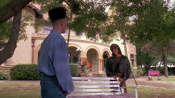 Movie still from “House Party 2” (1991), directed by Doug McHenry – A man and a woman are sitting on a bench outside; Wide shot, High angle