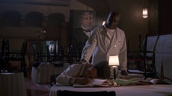 Movie still from “House Party 2” (1991), directed by Doug McHenry – A man standing next to a man laying on a table; Medium shot, Low angle