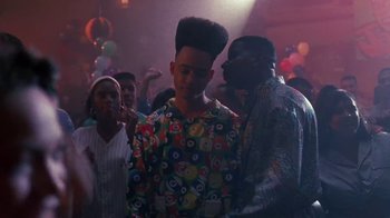 Movie still from “House Party 2” (1991), directed by Doug McHenry – A group of people in a room with balloons in the background; Medium shot, Over the shoulder angle