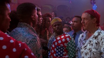 Movie still from “House Party 2” (1991), directed by Doug McHenry – A group of people standing around in a room; Medium shot, Over the shoulder angle