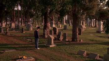 Movie still from “House Party 2” (1991), directed by Doug McHenry – A man standing in front of a grave in a cemetery; Extreme Wide shot, High angle