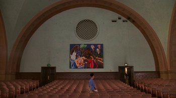 Movie still from “House Party 2” (1991), directed by Doug McHenry – A person standing in a room with a painting on the wall; Extreme Wide shot, Low angle