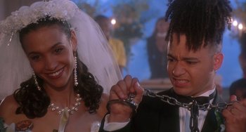 Movie still from “House Party 3” (1994), directed by Eric Meza – A bride and groom holding hands with a pair of handcuffs; Close Up shot, High angle