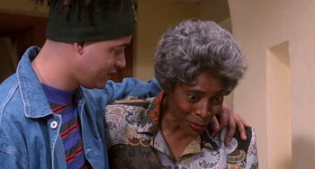 Movie still from “House Party 3” (1994), directed by Eric Meza – An older woman and a young man are hugging; Close Up shot, Low angle