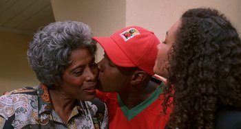 Movie still from “House Party 3” (1994), directed by Eric Meza – Two women and a man kissing each other in front of a wall; Close Up shot, Over the shoulder angle