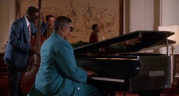 Movie still from “House Party 3” (1994), directed by Eric Meza – A man sitting at a piano in front of a group of people; Medium shot, Low angle